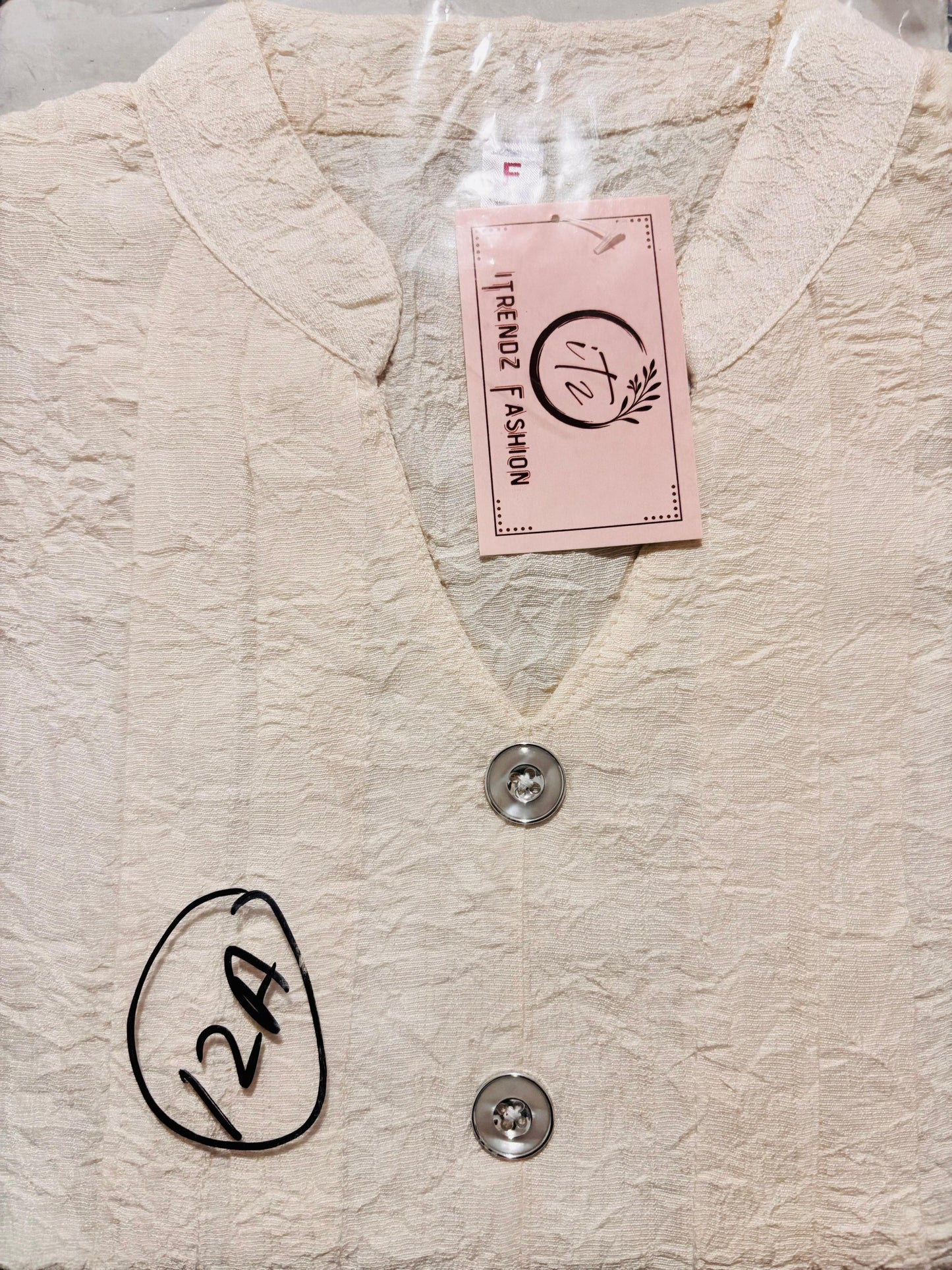 Beige textured fabric with a button and a pink tag labeled 'Trendy Fashion' on a white background.